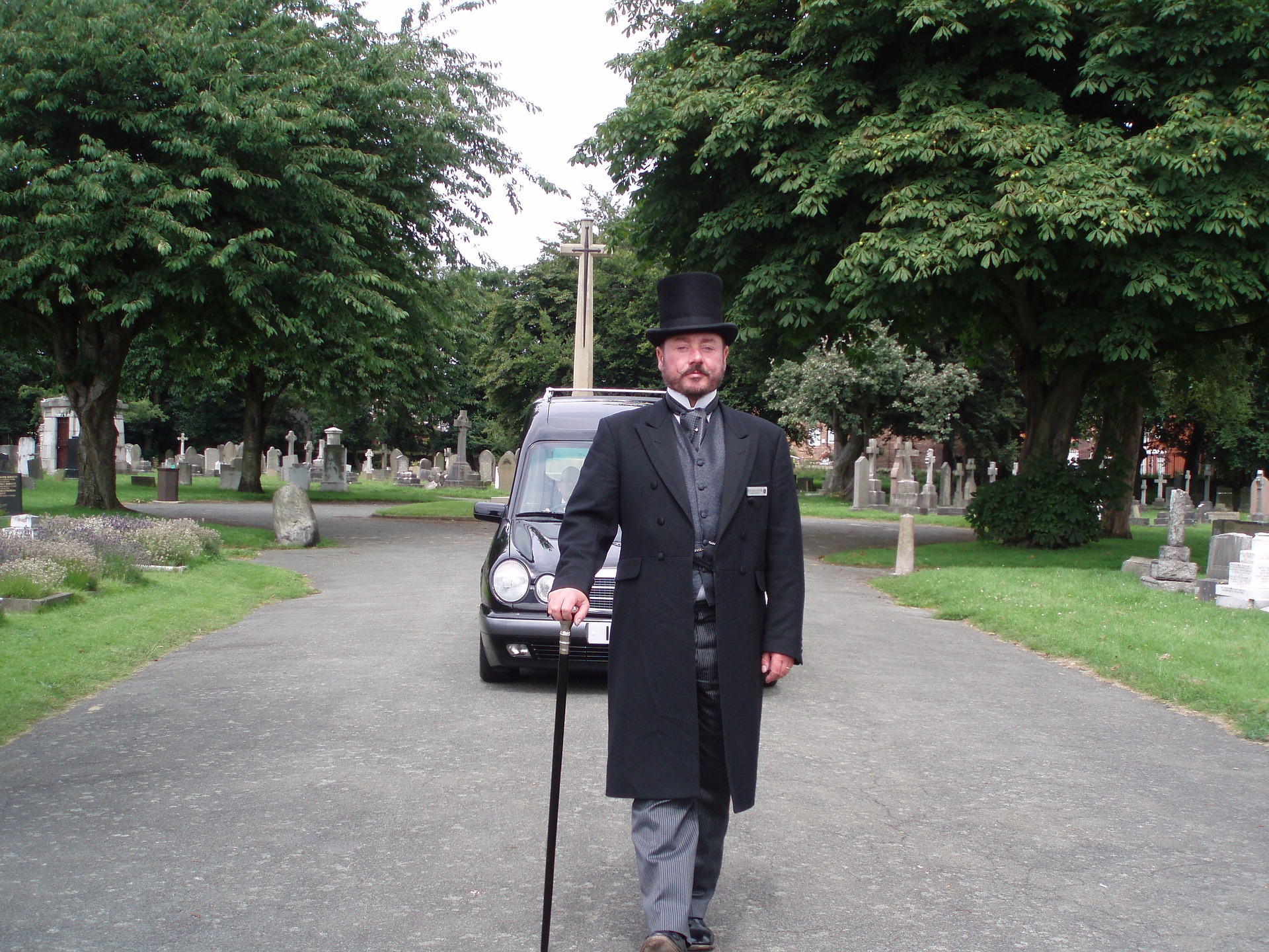 En begravningsentreprenör iklädd i rock och hatt